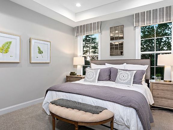 Owner s suite with tray ceiling and two large windows in a DRB Homes Whitaker II model home.