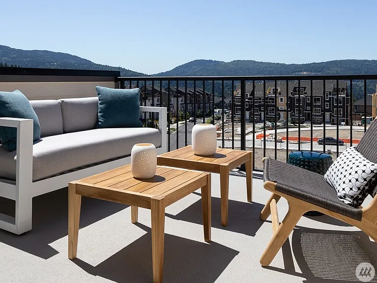 Private covered deck with comfortable outdoor living space and scenic neighborhood and mountain views - the perfect spot to enjoy your morning coffee or unwind in the evening.