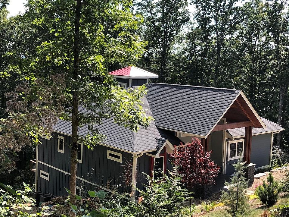 OUR CONTEMPORARY TREE HOUSE IS A 2 STORY HOME, BUILT ON A SLOPE WITH A WALKOUT BASEMENT LEADING TO A LARGE DECK WITH SWIM SPA. 2 CAR GARAGE BELOW & A CUPOLA WITH A LITTLE RED MEDAL ROOF ABOVE. 2 DRIVEWAYS: ONE IN FRONT FOR VISITORS AND ONE THAT LEADS TO