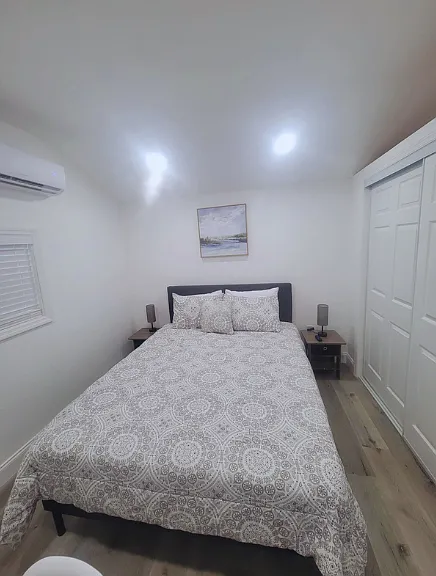 Charming room with queen bed, 3 pillows, lamps, nightstands & wall art