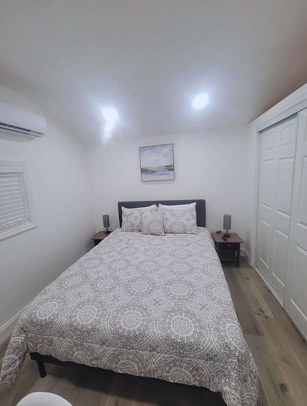 Charming room with queen bed, 3 pillows, lamps, nightstands & wall art