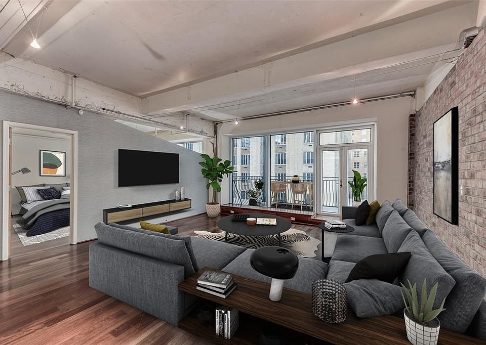 The open living space view including the primary bedroom and balcony all virtually staged.