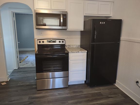 Range microwave and glasstop stove. Recently remodeled kitchen cabinets. Vinyl plank gray flooring in the kitchen.