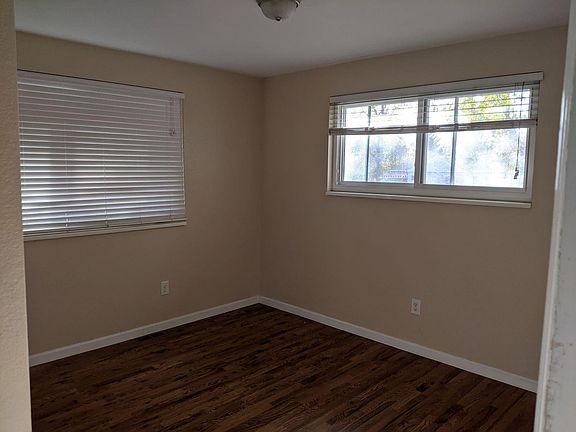 Sunny master bedroom with wood floors.