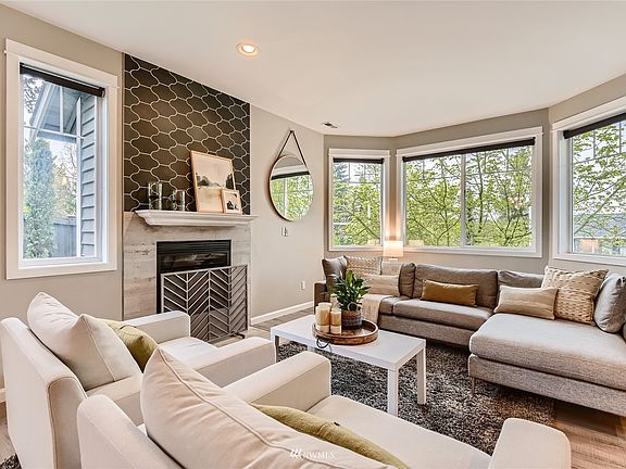 Picture windows, new LVP flooring, and the designer tile gas fireplace make this living room a special place to be.