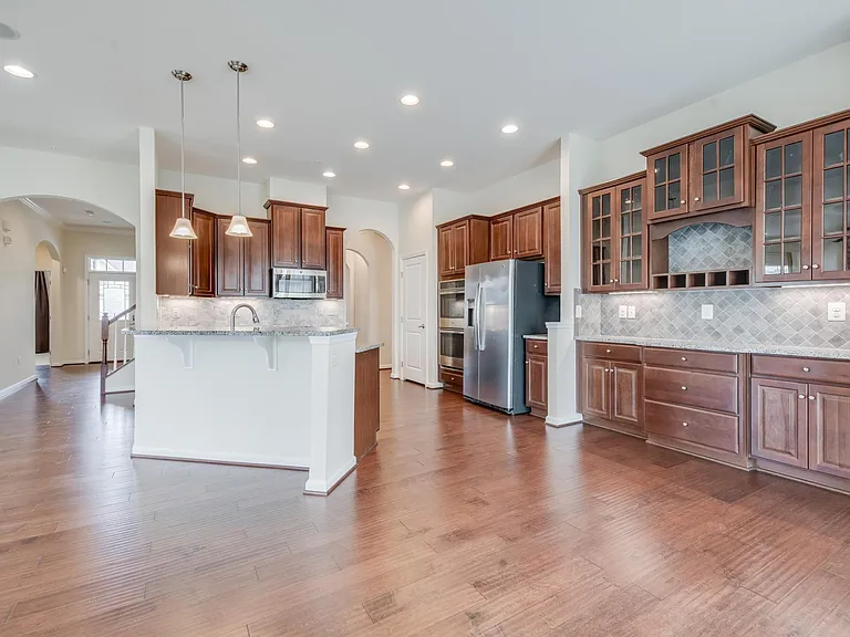 Chef's Kitchen with Granite Counter and Backsplash and built-in Serving table and cabinetry