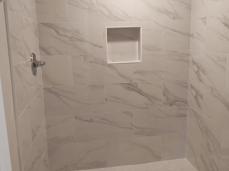 Master shower with new tile and fixtures. Glass Shower door has been installed.