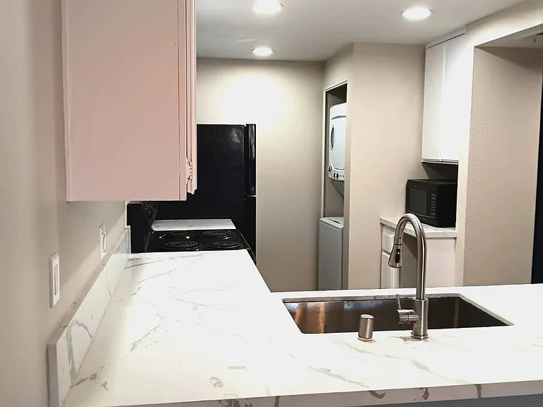 Washer dryer at back of kitchen. Quartz on all countertops.