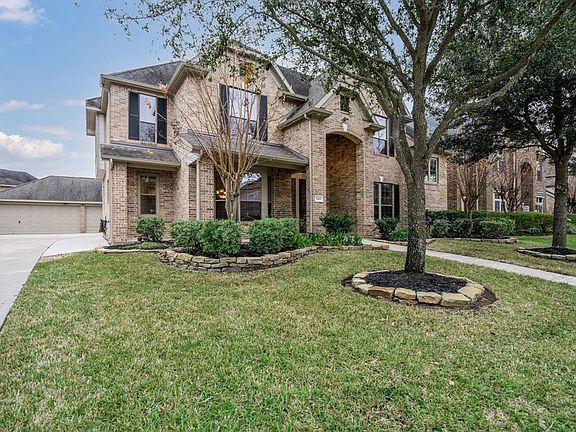 Side veiw of home with covered front porch, 3 car garage and long driveway