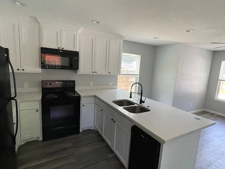 Large kitchen with quartz countertop and all black appliances