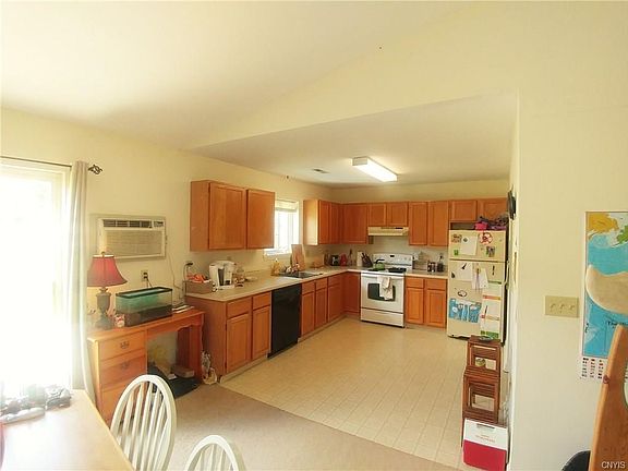 Kitchen includes refrigerator, range, and dishwasher. Window above sink overlooks back yard.