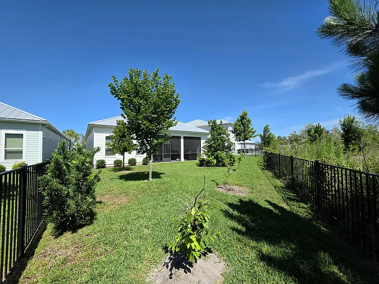 Fenced backyard with screened lanai