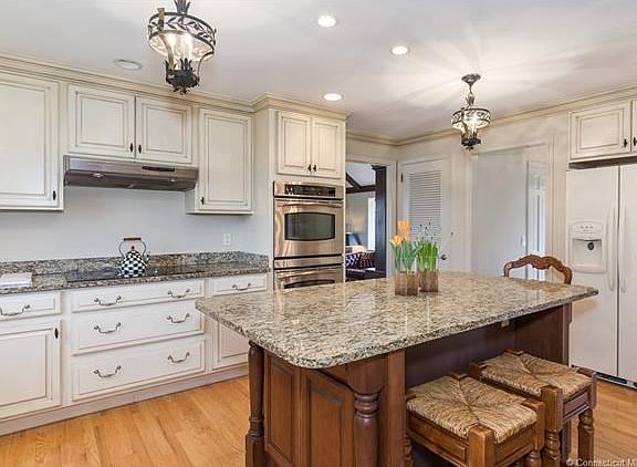 Beautiful lighting over the granite center island (w/seating).