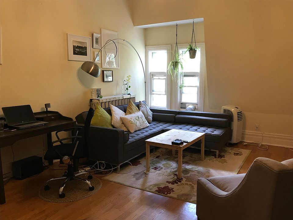Living room is bright, spacious, high ceilings.