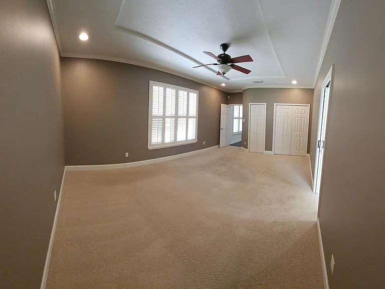 Reverse view of master, large wood shuttered windows with view to the backyard.