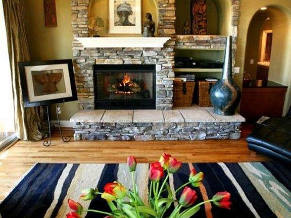 "Vaulte ceiling and floor to ceiling stacked stone fireplace in the living room"