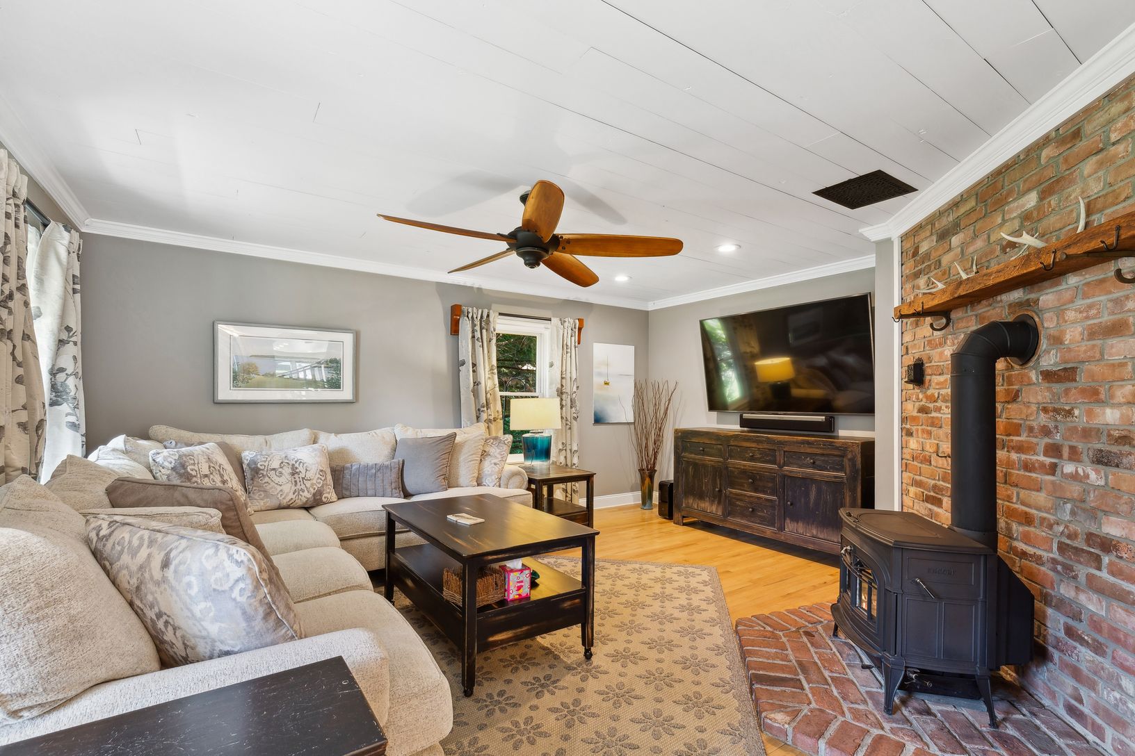  The Living Room Upon Entry. Lush Wrap-Around Couch. Large Flat Screen Television. Wood-Burning Stove