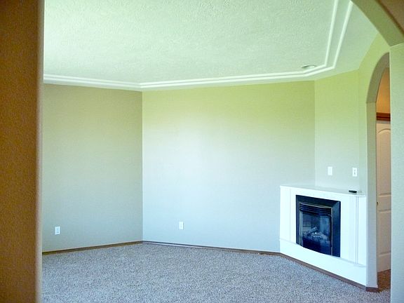Formal living room with electric fireplace is to the left of the entry