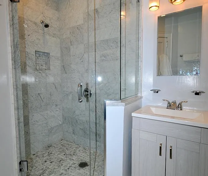 Fully renovated bath with marble tiled step-in shower.