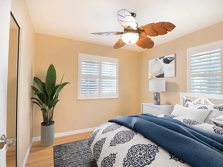 Bedrooms with wall mount air-conditioning, decorative fans, and shutters