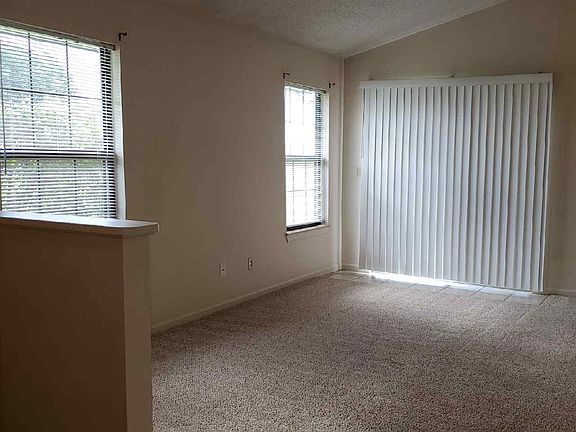 Living Room with vaulted ceiling & side patio door