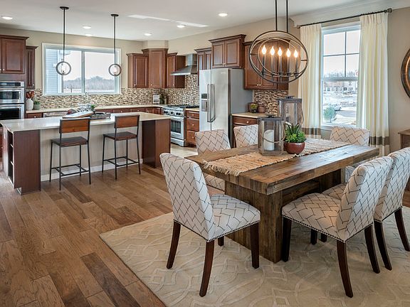 open layout showcasing hardwood flooring between kitchen and dining area