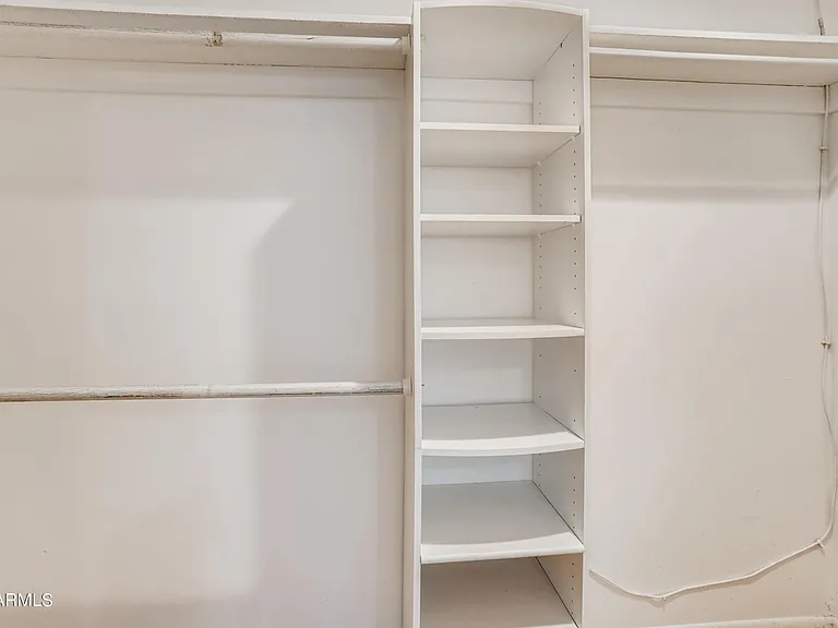 Primary bedroom closet 1 of 2 is a walk in with built in shelving.