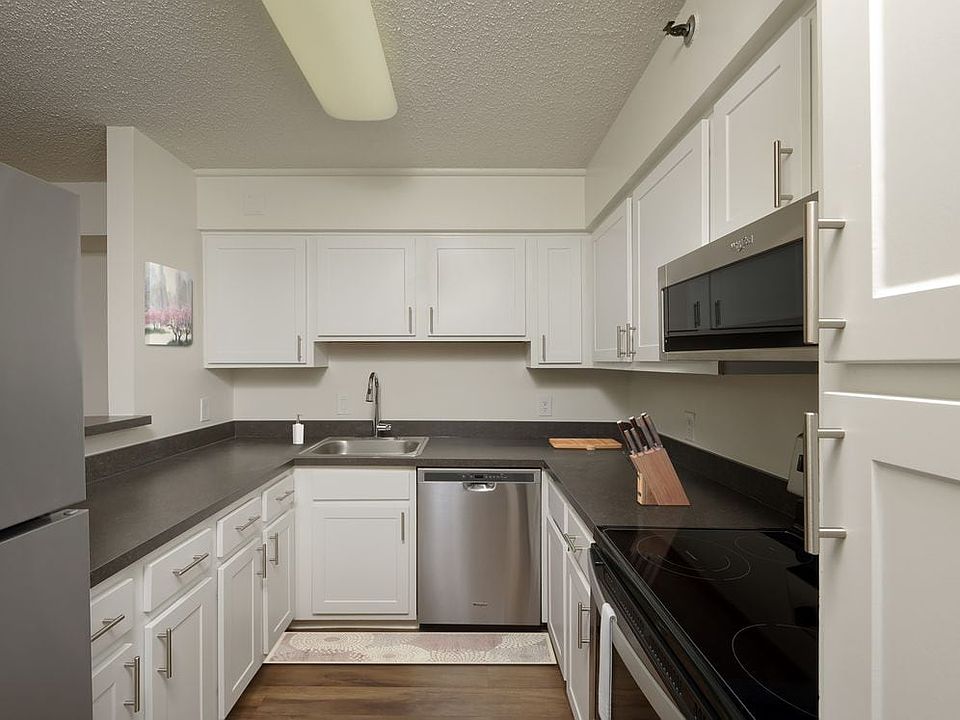 Finish Package III kitchen with white cabinetry, stainless steel appliances, and hard surface plank flooring