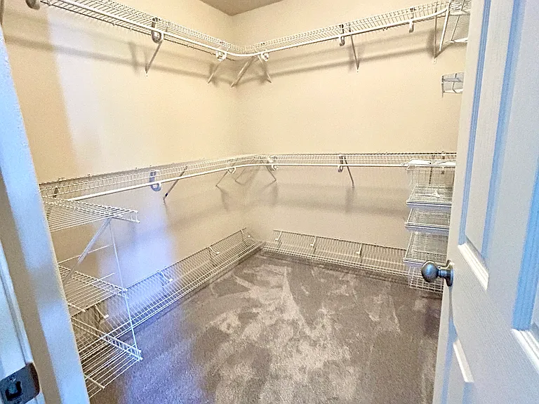 Primary walk in closet with closet organizer system