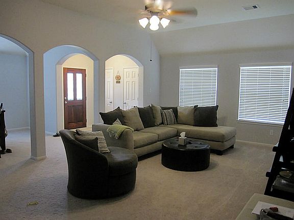 SPACIOUS LIVING AREA OFFERS NEUTRAL CARPET, LARGE WINDOWS & ARCHED VIEW INTO THE FORMAL DINING ROOM