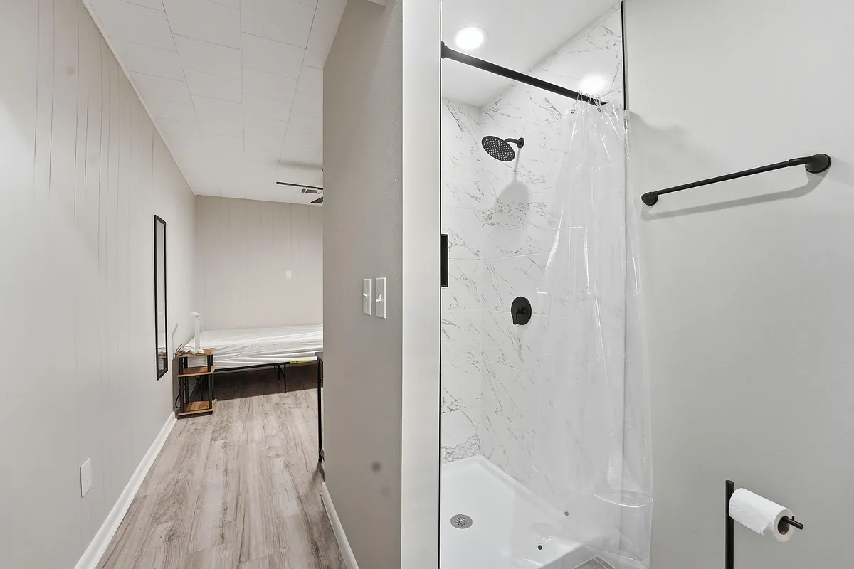 Updated bathroom with a tiled tub/shower surround and matte black fixtures, set just off the bedroom for easy access. - Mulberry Ln