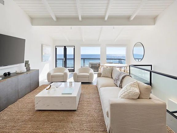 The comfortable designer sofa faces a large smart TV