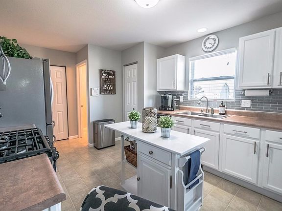 RECENTLY UPDATED KITCHEN W/WHITE CABINETS, LEVERS, ISLAND, BUILT-IN DESK, BACKSPLASH, UPGRADED FAUCET, HIGH END STAINLESS STEEL APPLIANCES, PANTRIES & MORE!