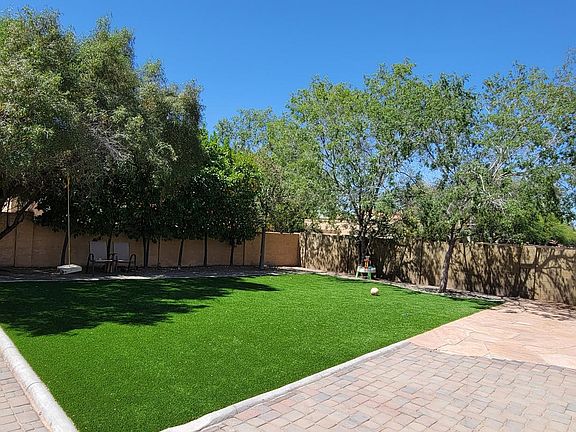 Huge yard with artificial grass and paved paths around it. Lots of space for open play for kids. Trees provide privacy and a relaxing view.