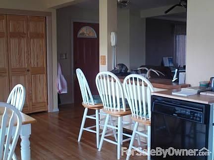 Kitchen and entry way
						:
						From the sink area note the bar on the right and the hard wood floors.