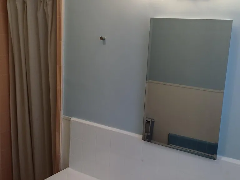 Bathroom view from bathtub corner. Bath tub, vanity, separate shower.