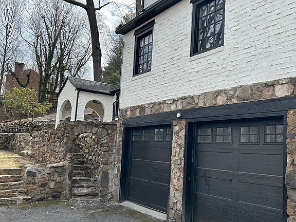 Elaborate stone work and two car garage with EV charging station
