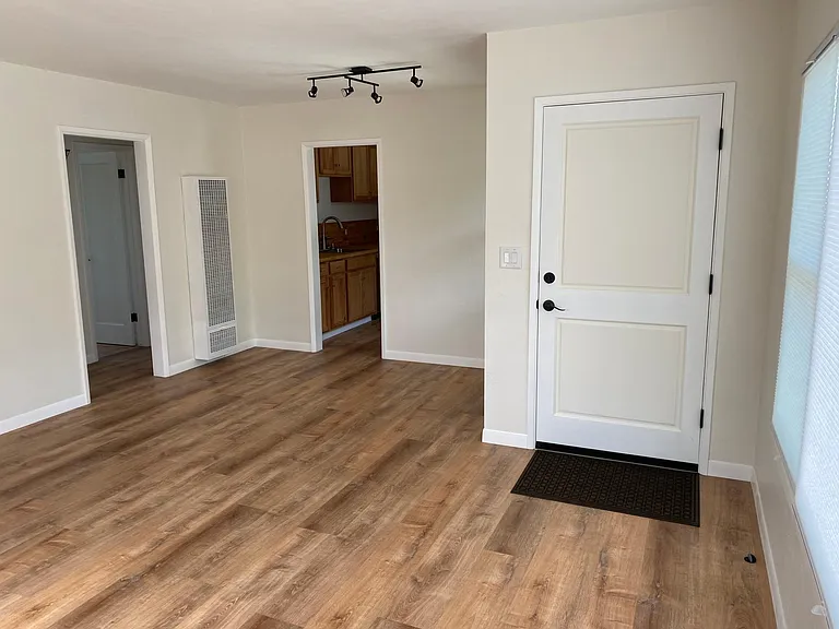 Living room facing north, kitchen door in middle, hallway, left.