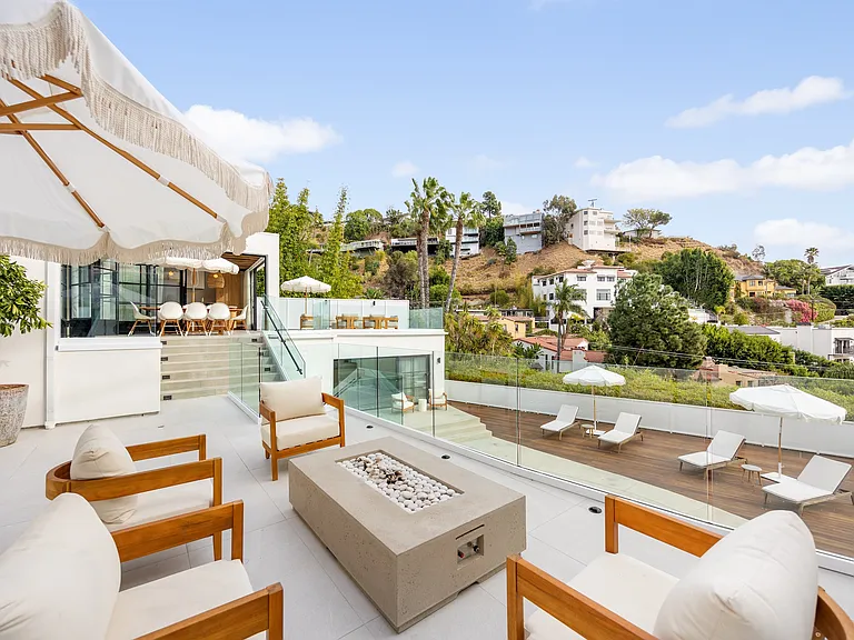 Relax by the fire pit, set in a sleek concrete base, with panoramic hillside views.