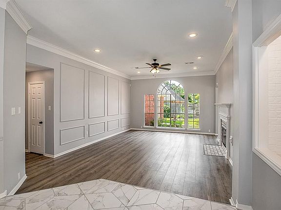The Living room is bright and cheerful with a Large beautiful window and gas fireplace. New floors and fixtures.