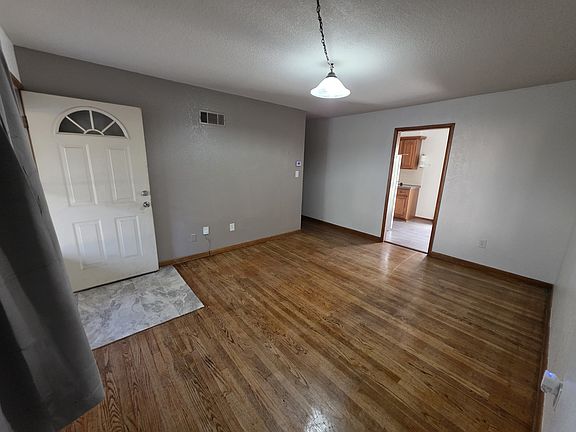 Living room with real oak floors, new paint, windows, faux wood blinds, and black out curtains.