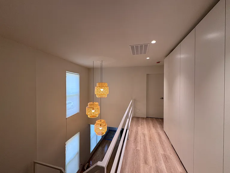 Airy upstairs hallway with modern lighting and clean architectural lines.