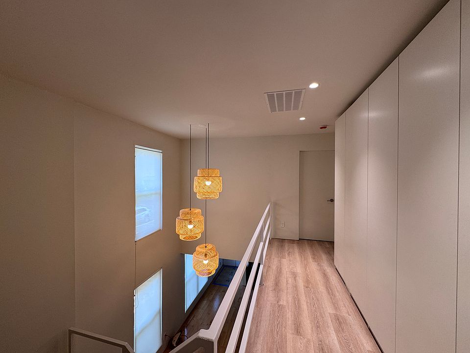 Airy upstairs hallway with modern lighting and clean architectural lines.