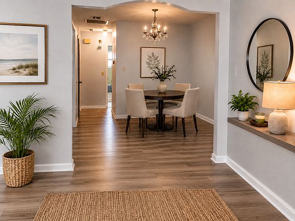 Welcoming entryway looking toward the dining area, highlighting the clean layout, fresh interior paint, and seamless new flooring throughout