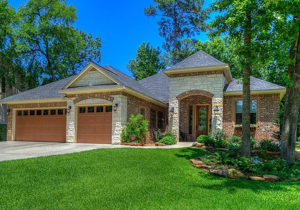 Beautiful single story home in April Sound with a 3 car garage, professionally landscaped front and 