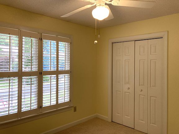 Bedroom features plantation shutters and a spacious closet