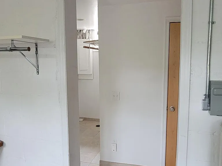 Laundry room to storage room (L), Bathroom (wood door seen)