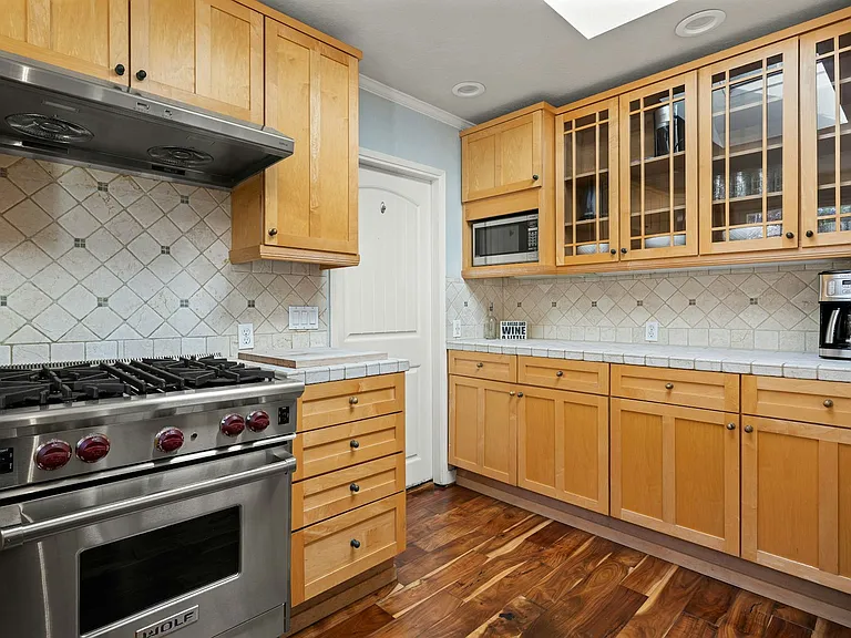 Chef-ready and family-approved this warm, spacious kitchen features a high-end Wolf range, ample counter space, and generous storage, making it ideal for everything from weeknight dinners to holiday feasts.