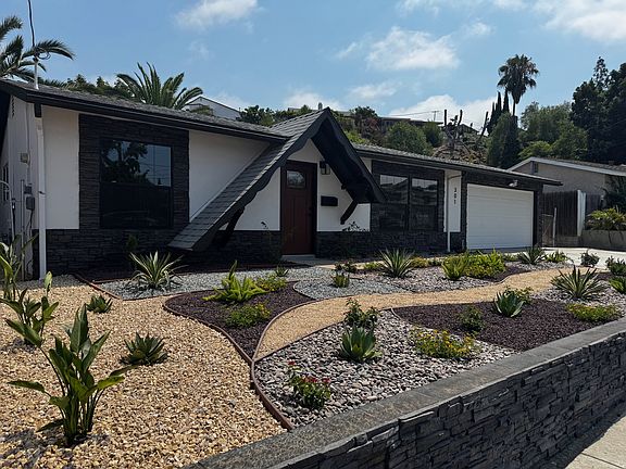 Landscape in front includes birds of paradise, rosemary, aloe, lantana, asparagus, and solanum among others.