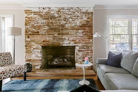 Floor to ceiling stone fireplace in living room.